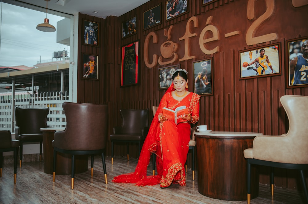 a woman in a red dress sitting on a chair