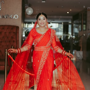 a woman in a red sari posing for a picture