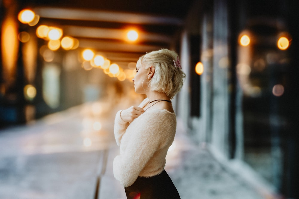 a woman standing on a sidewalk in front of a building