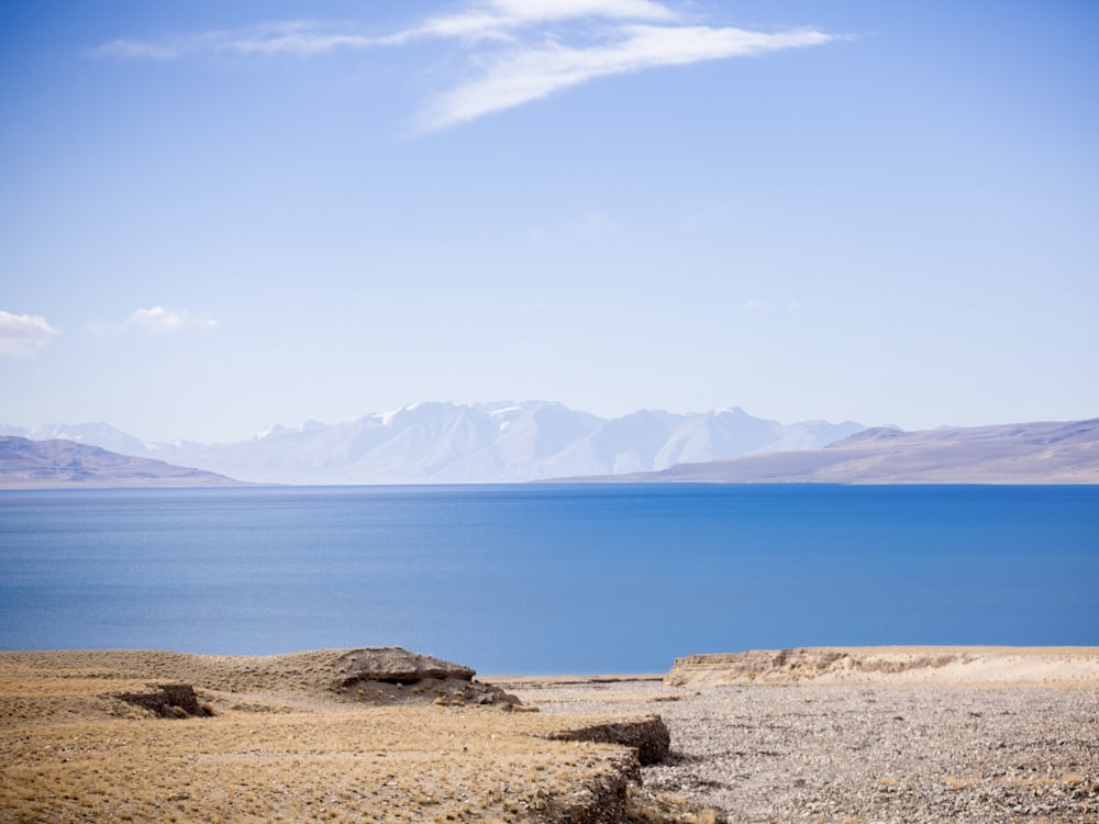 a large body of water with mountains in the background