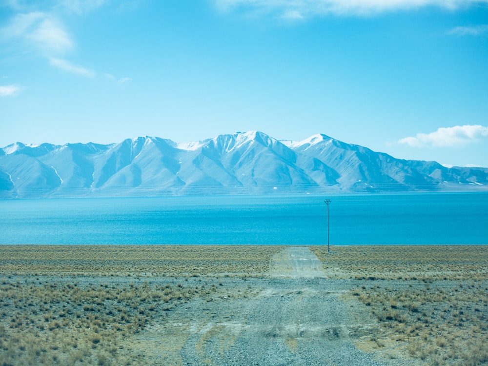 a dirt road with mountains in the background