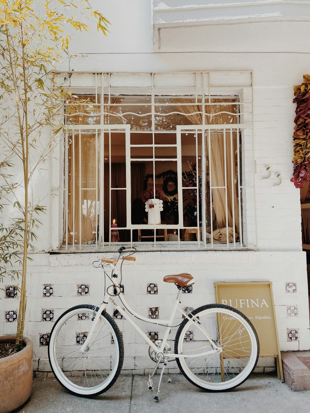 a white bicycle parked in front of a window