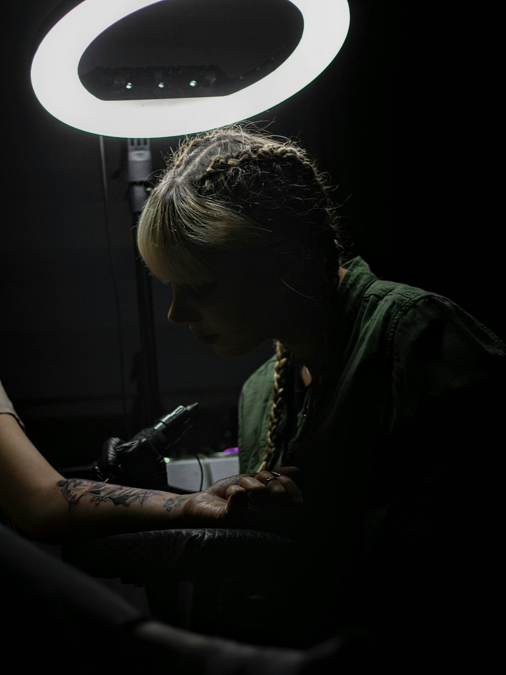 a woman sitting in a dark room with a light on her head