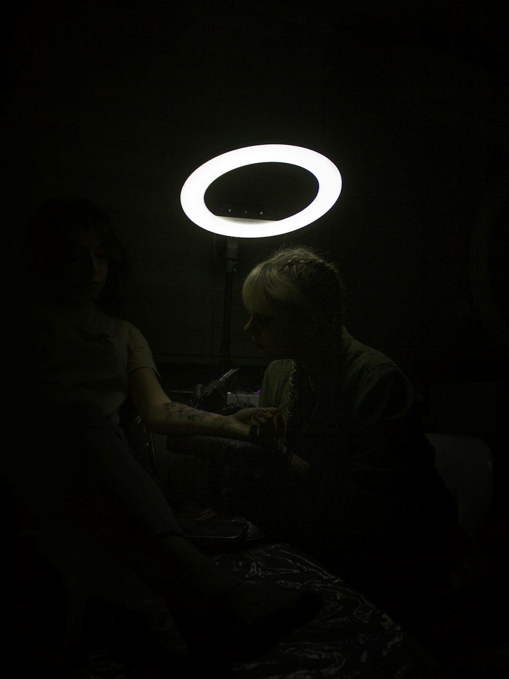 a man and a woman sitting in a dark room