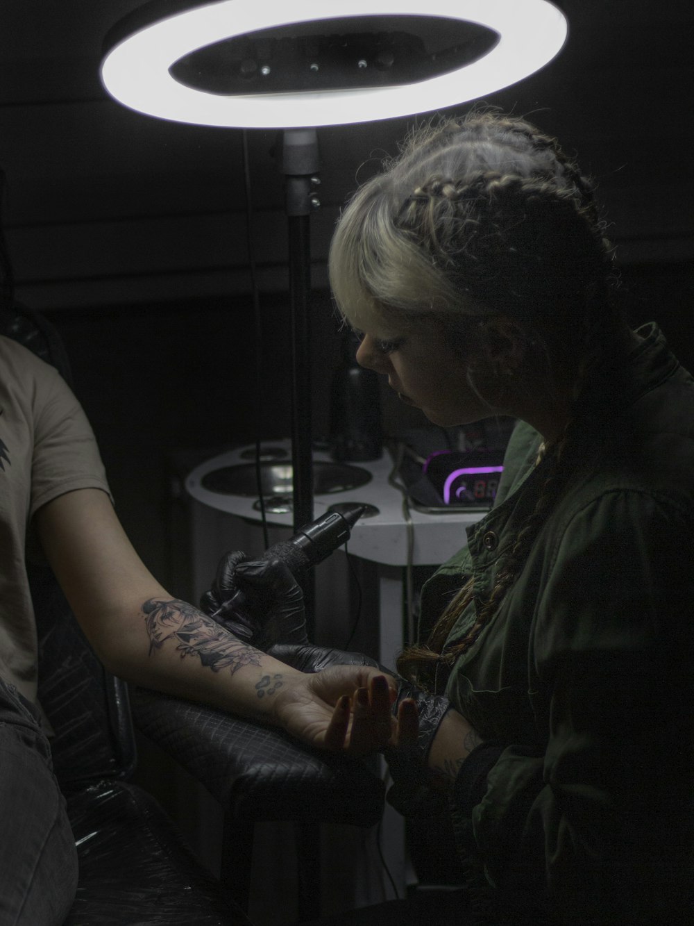 a woman getting a tattoo on her arm