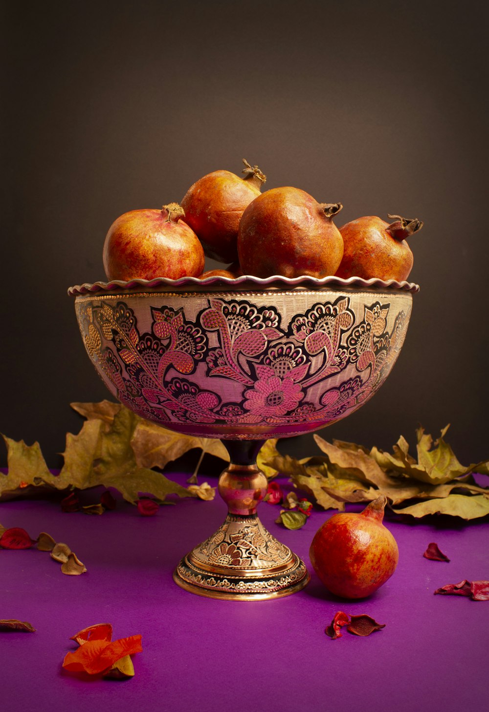 a bowl filled with apples sitting on top of a purple table