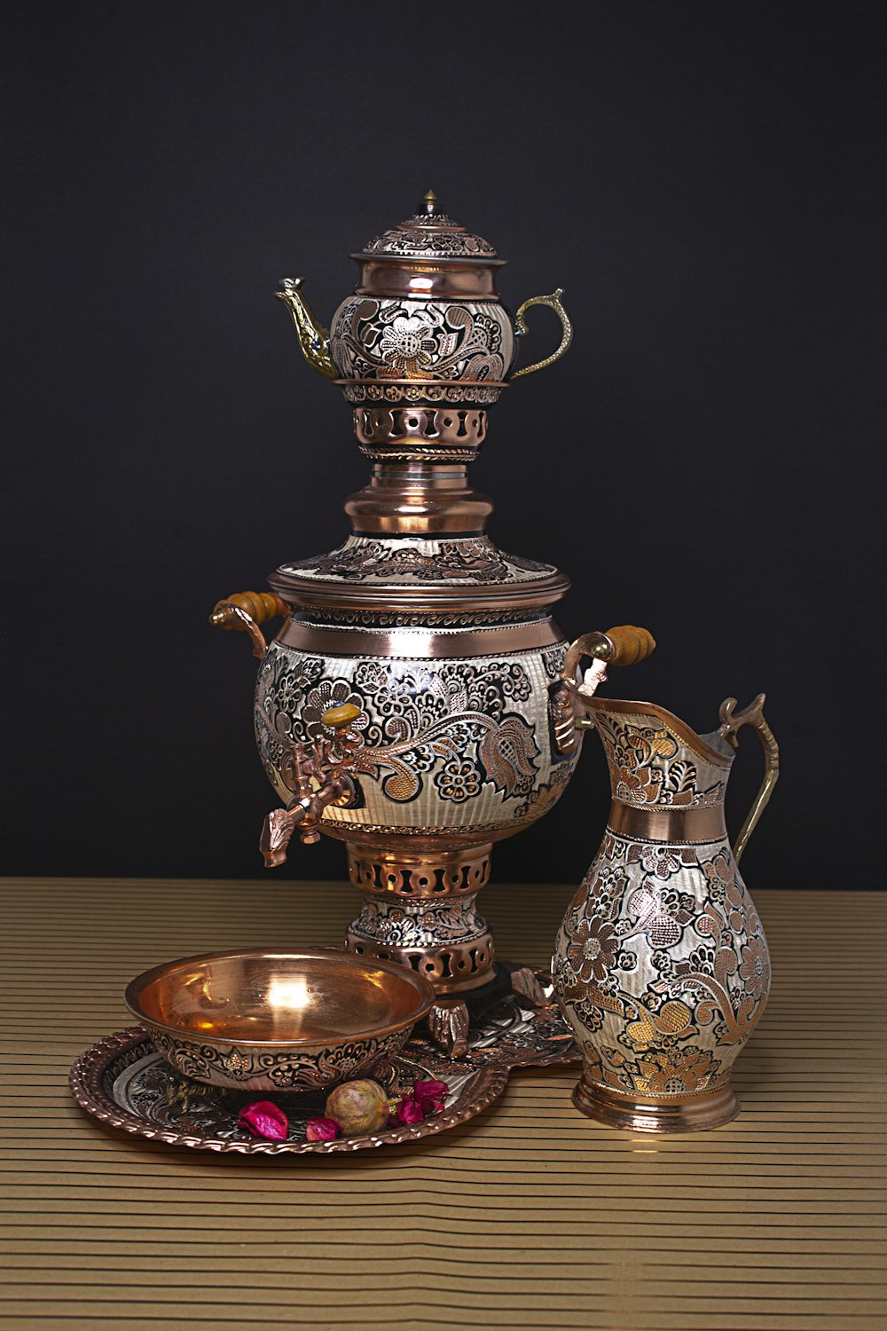 an ornately decorated tea pot and saucer on a table