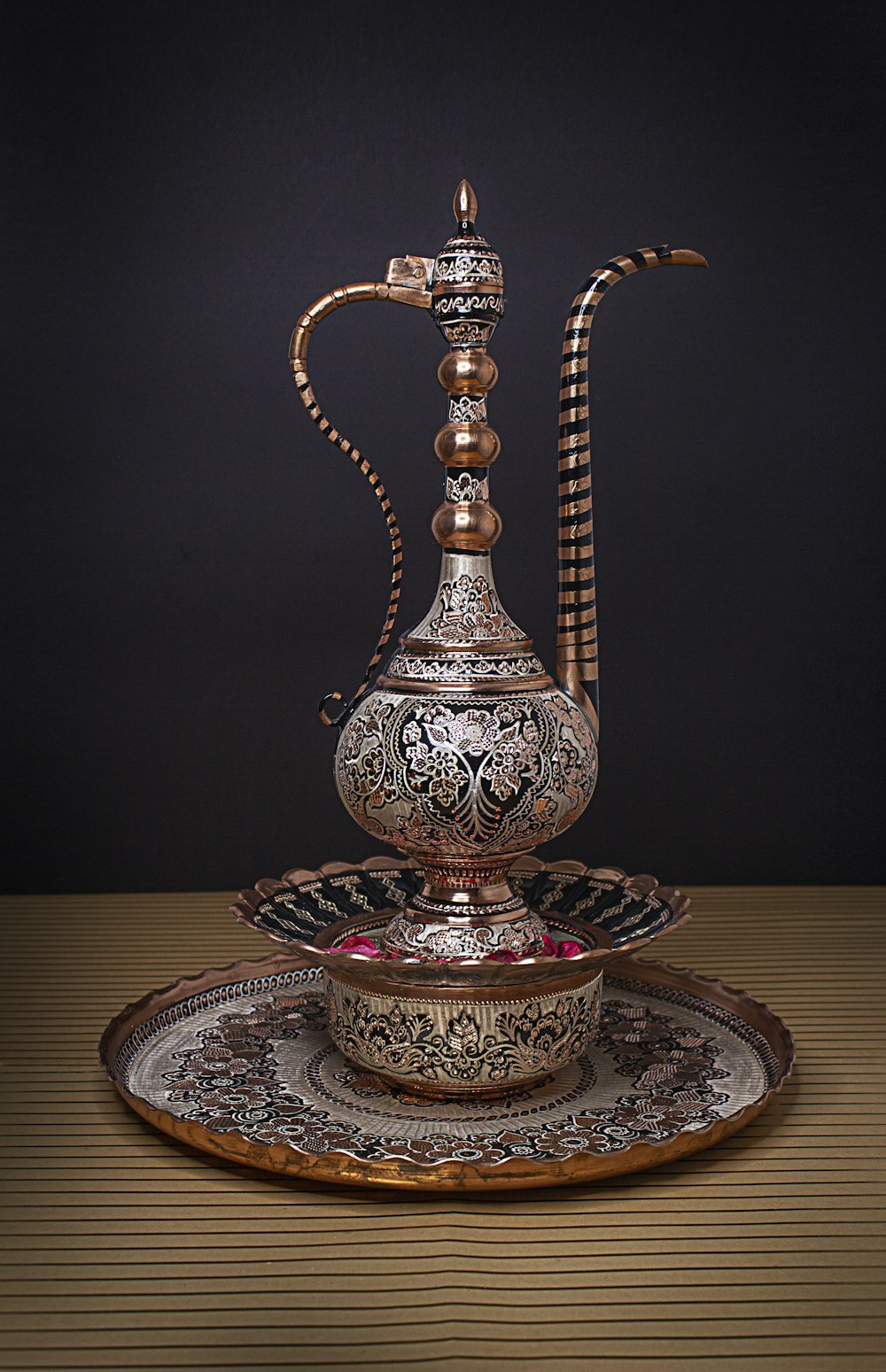 a silver tea pot sitting on top of a plate