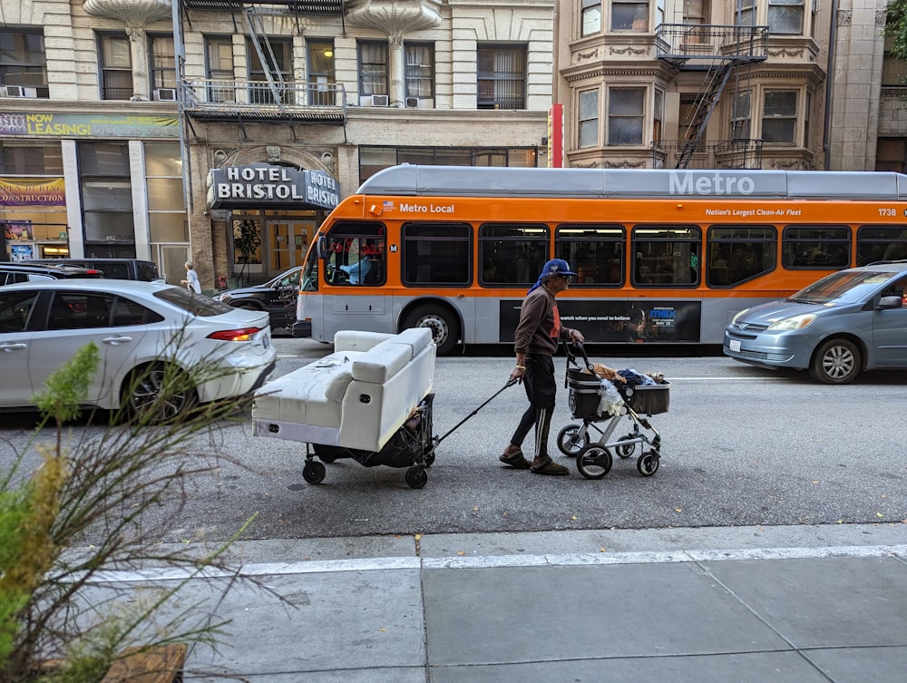 a woman pushing a stroller next to a bus