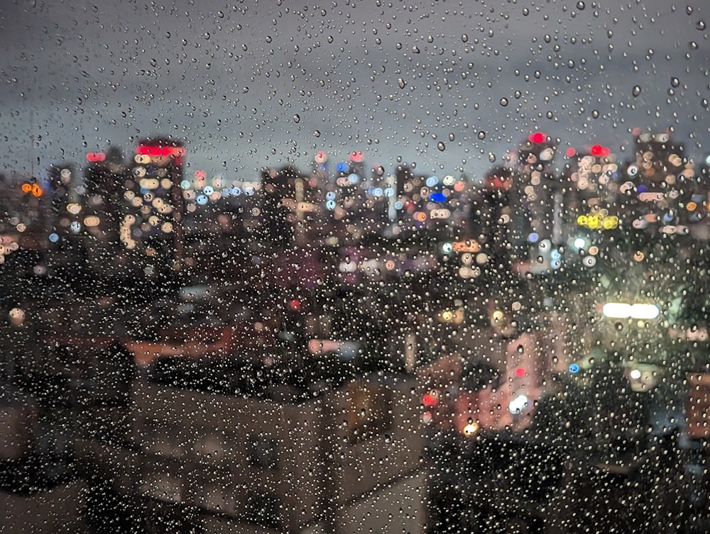 a view of a city at night through a rain covered window