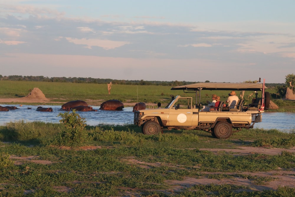a safari vehicle with people in the back of it