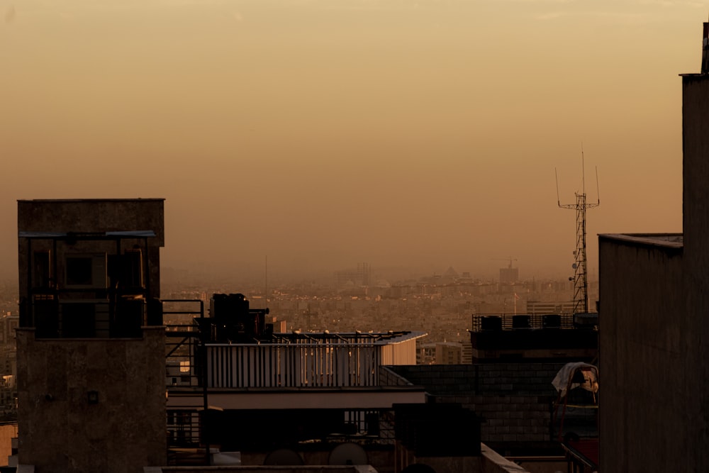 a view of a city from a rooftop at sunset