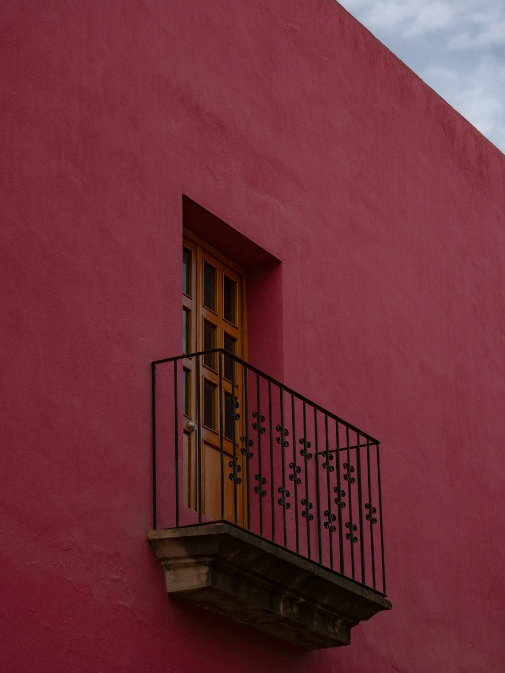 a red building with a balcony and a yellow door