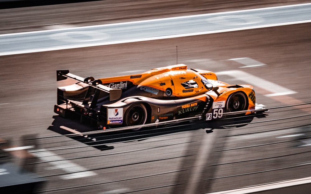 une voiture de course roulant sur une piste pendant la journée