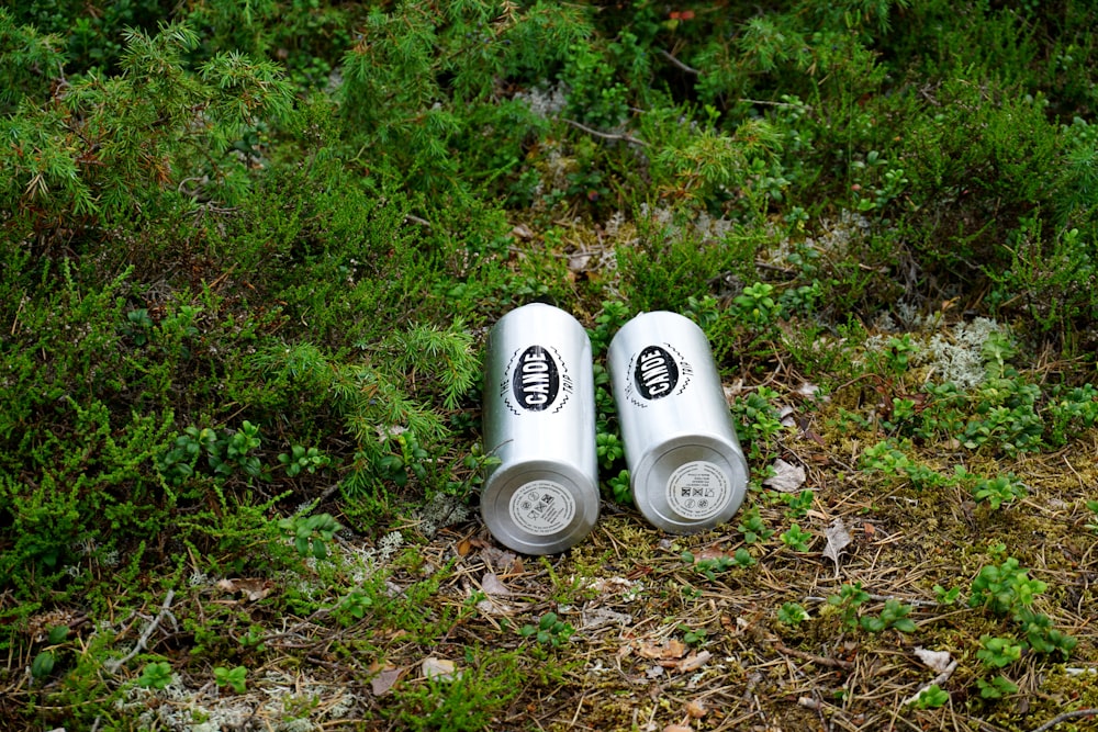 a couple of white cups sitting on top of a grass covered field