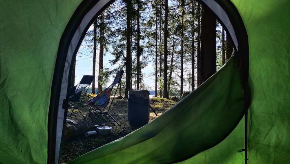 a tent in the woods with a tent in the foreground