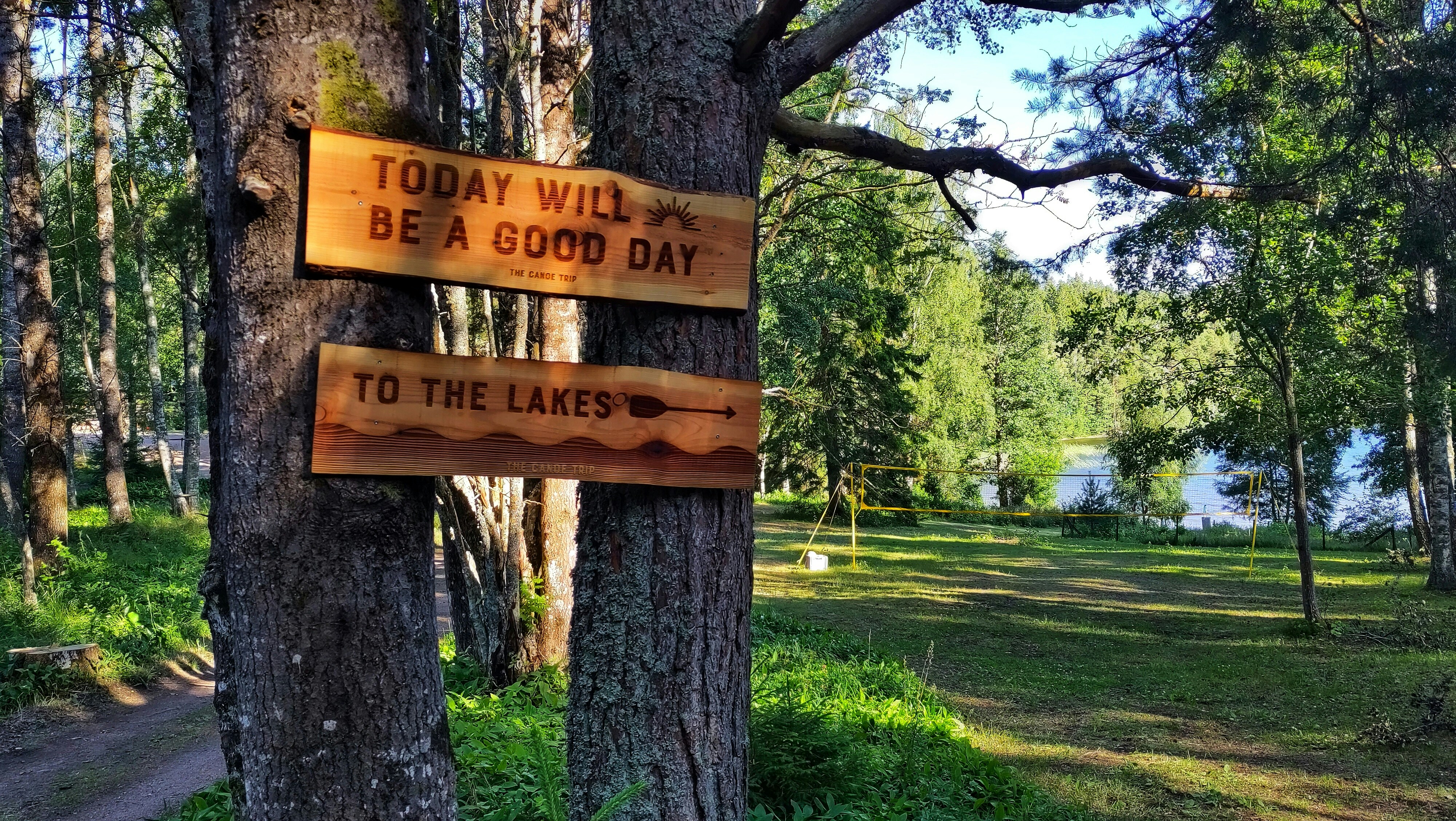 a sign on a tree that says today will be a good day to the lakes