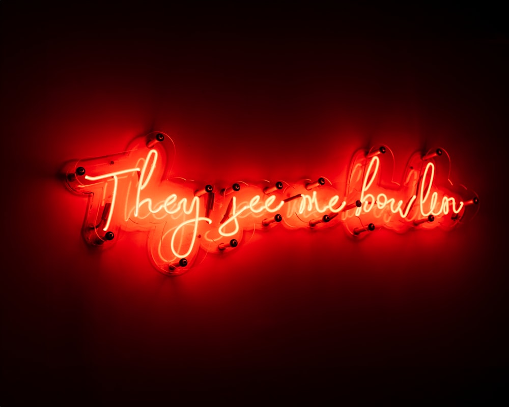 a red neon sign that says they seem to be in love