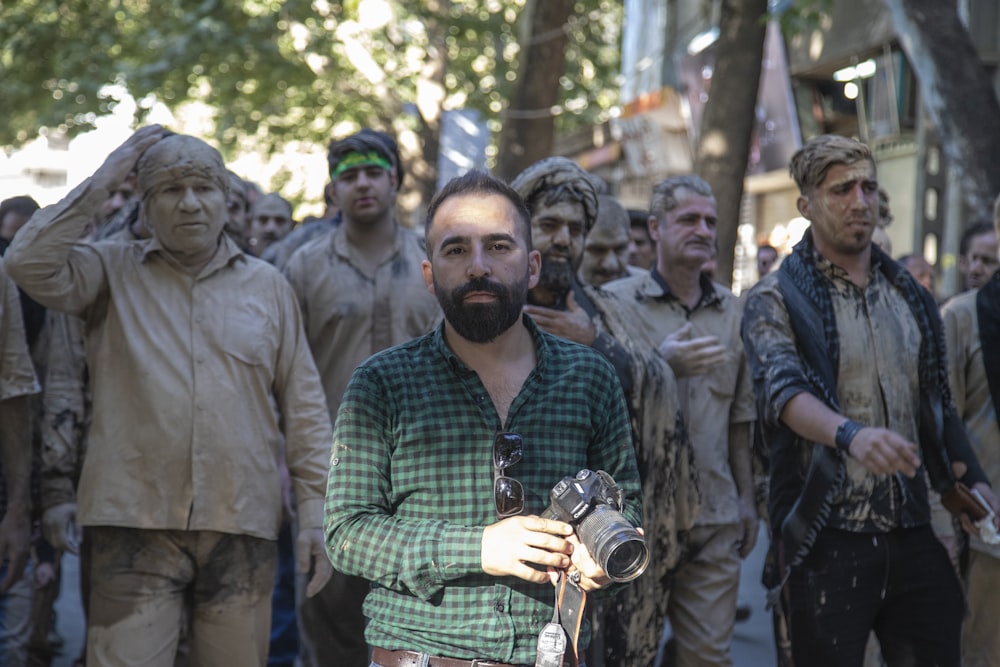 a man with a camera standing in front of a group of people