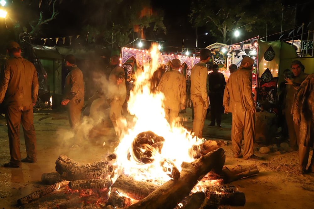 a group of people standing around a fire