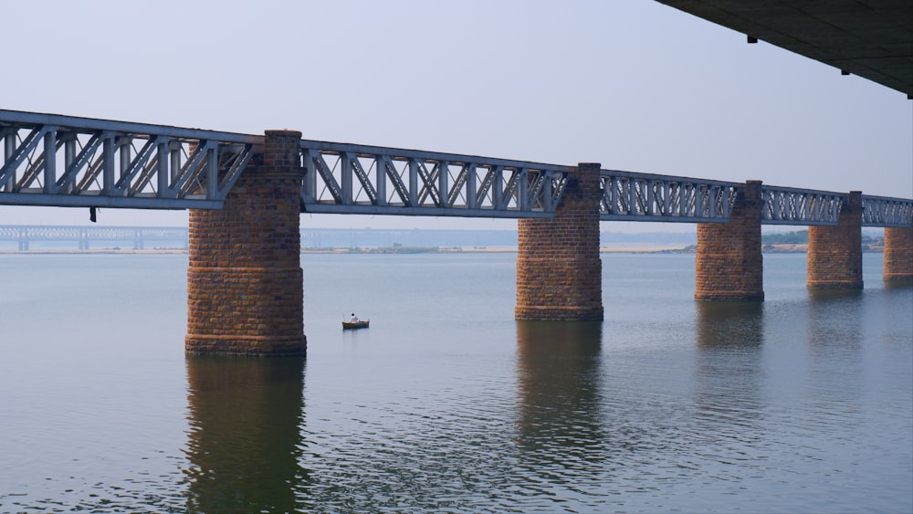 a bridge over a body of water with a boat in the water