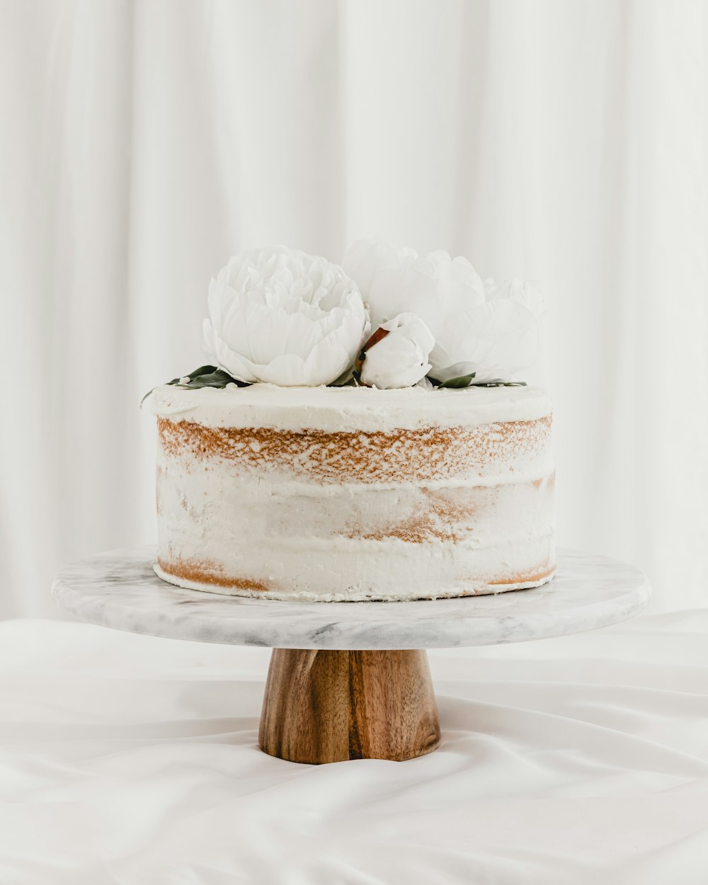 흰색 프로스팅과 꽃을 얹은 케이크