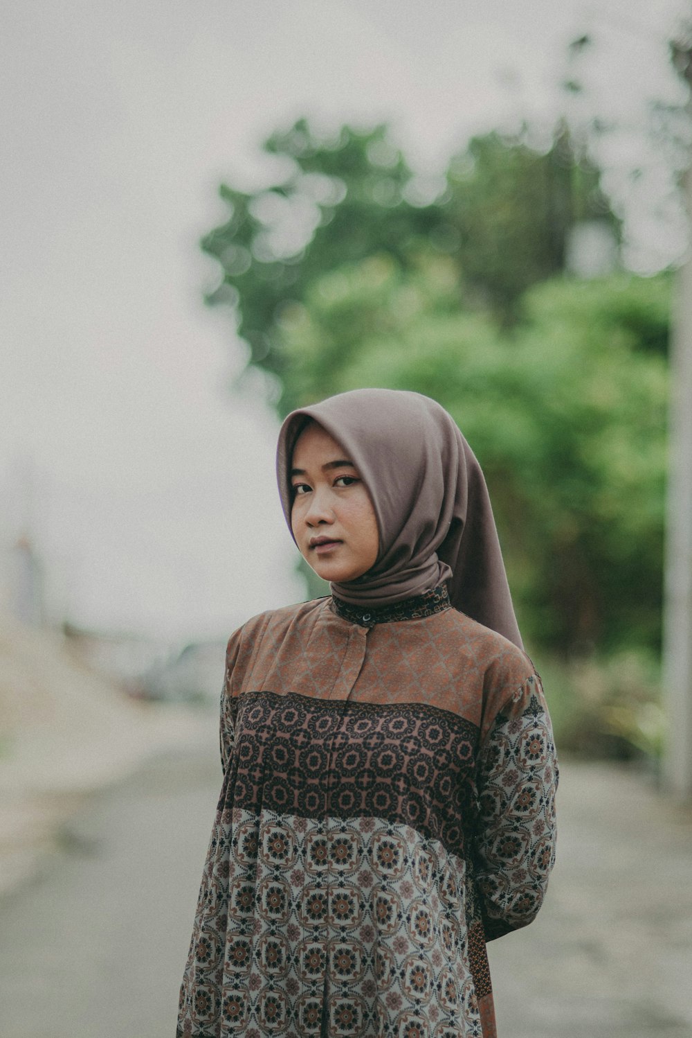 a woman in a hijab standing on a street