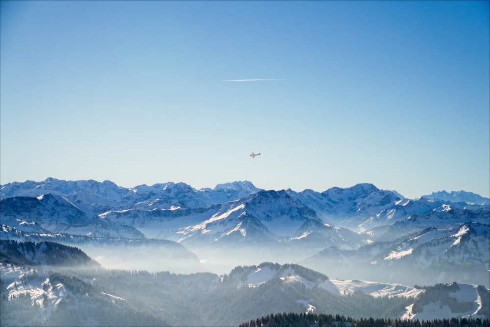 a plane flying over a mountain range covered in snow