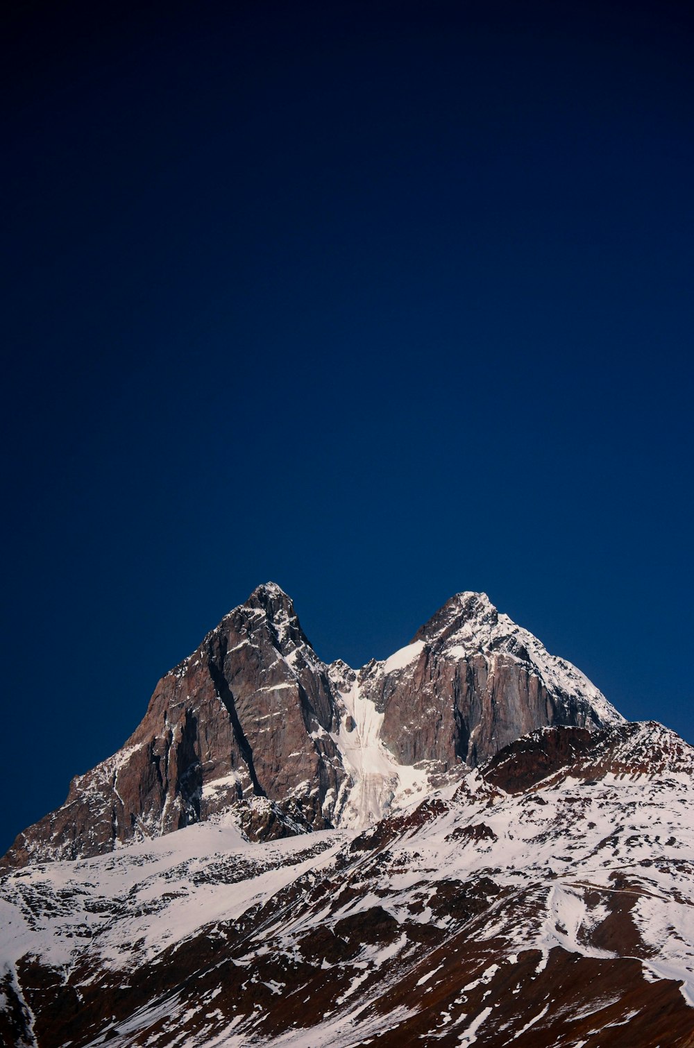 a snow covered mountain under a blue sky