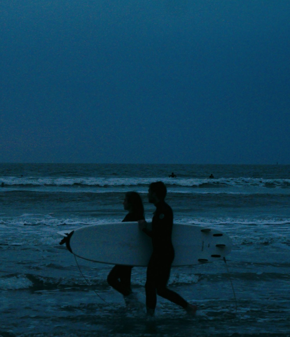 a couple of people that are walking in the water