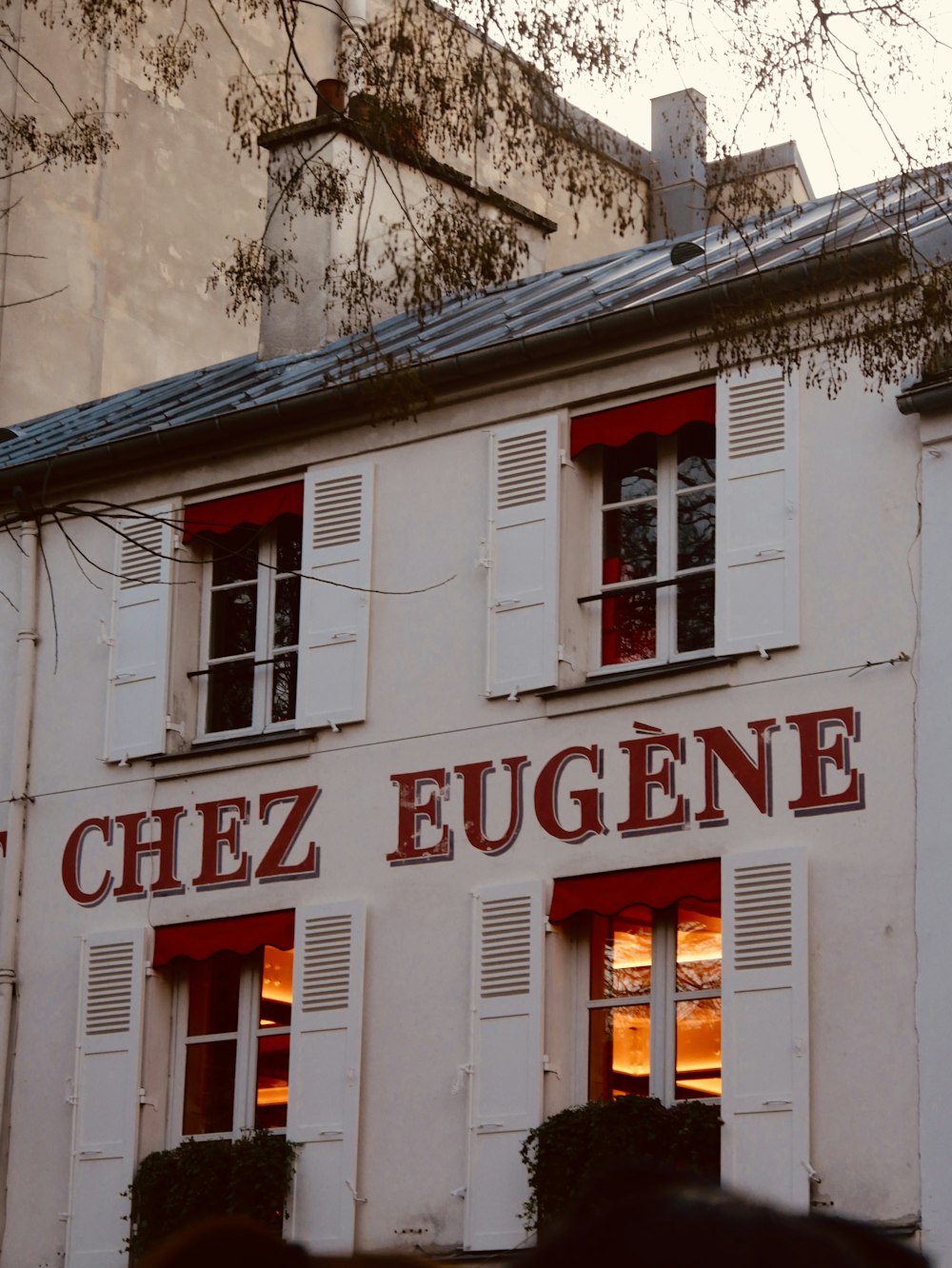 a white building with red shutters and windows