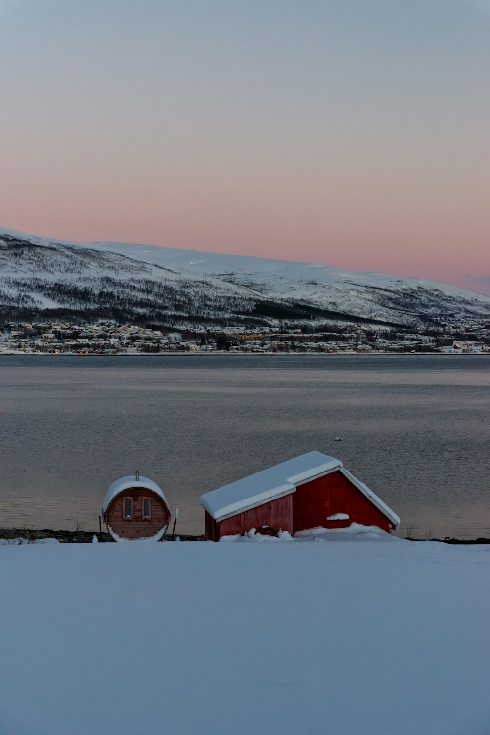 a red barn sitting on top of a snow covered field