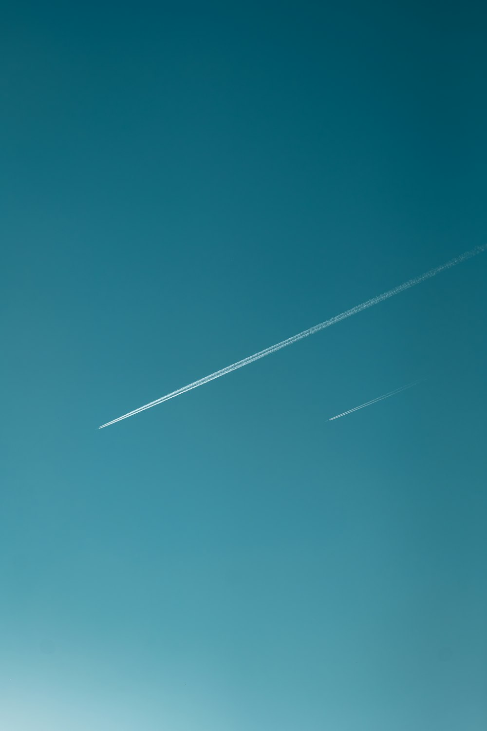 a plane flying in the sky with a contrail