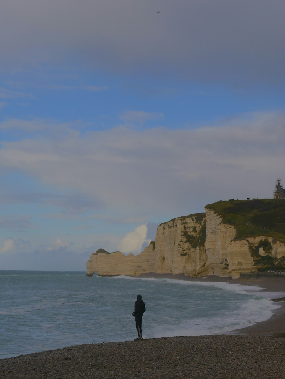 a person standing on a beach next to the ocean