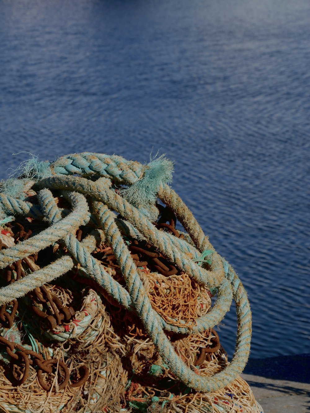 a pile of rope sitting next to a body of water