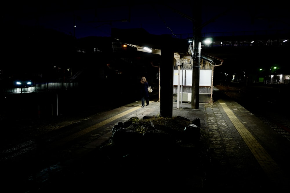 una persona in piedi su una piattaforma di notte