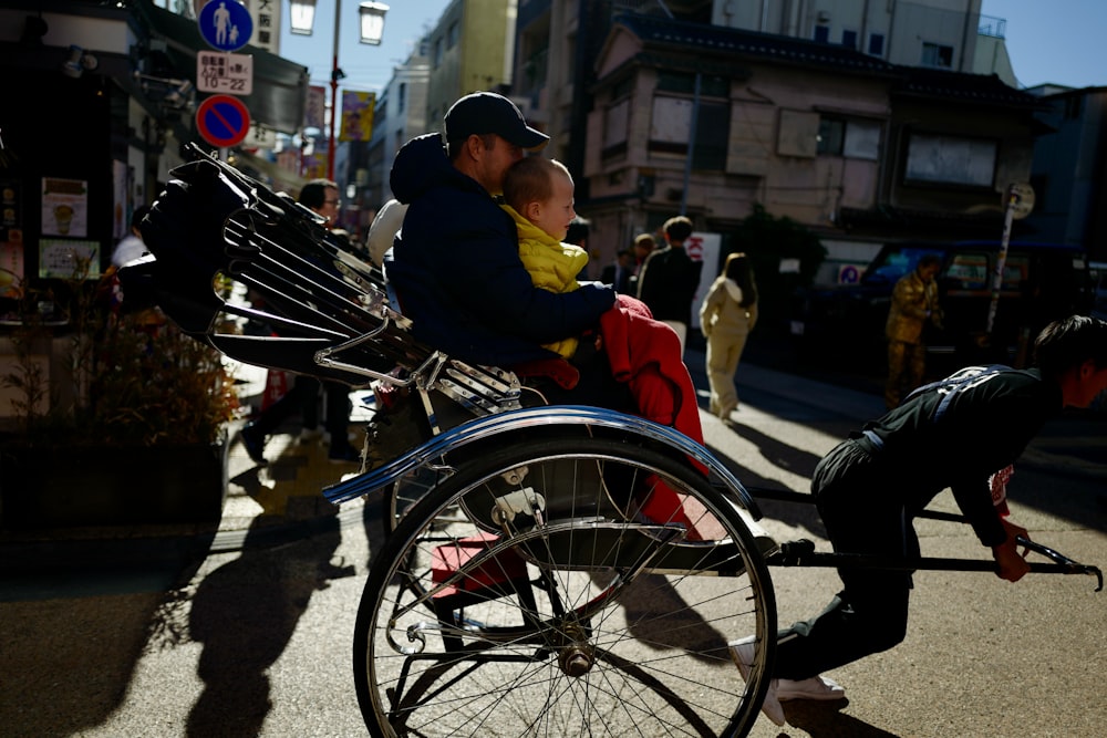 un homme poussant un bébé dans un fauteuil roulant
