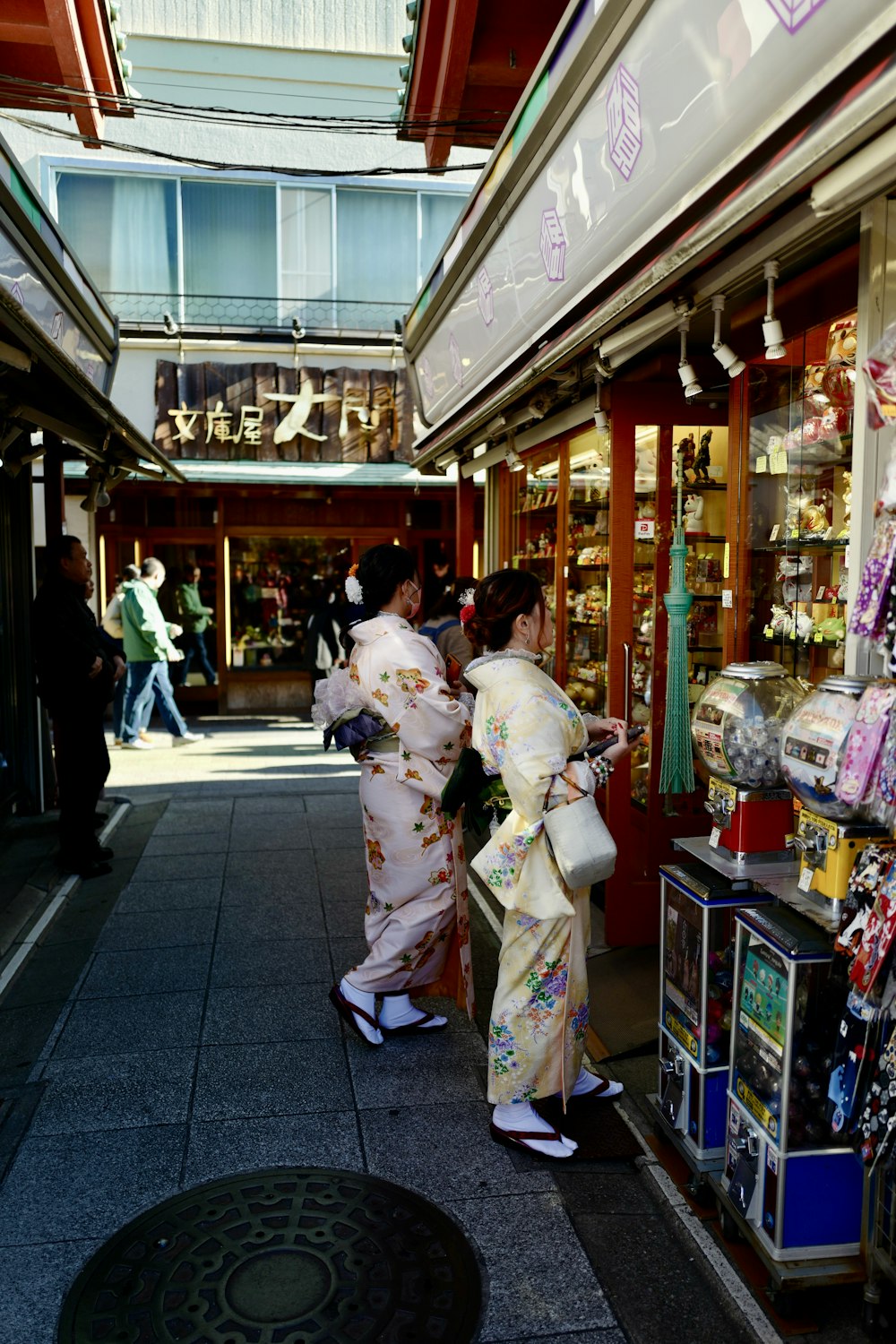 a couple of women standing next to each other in front of a store