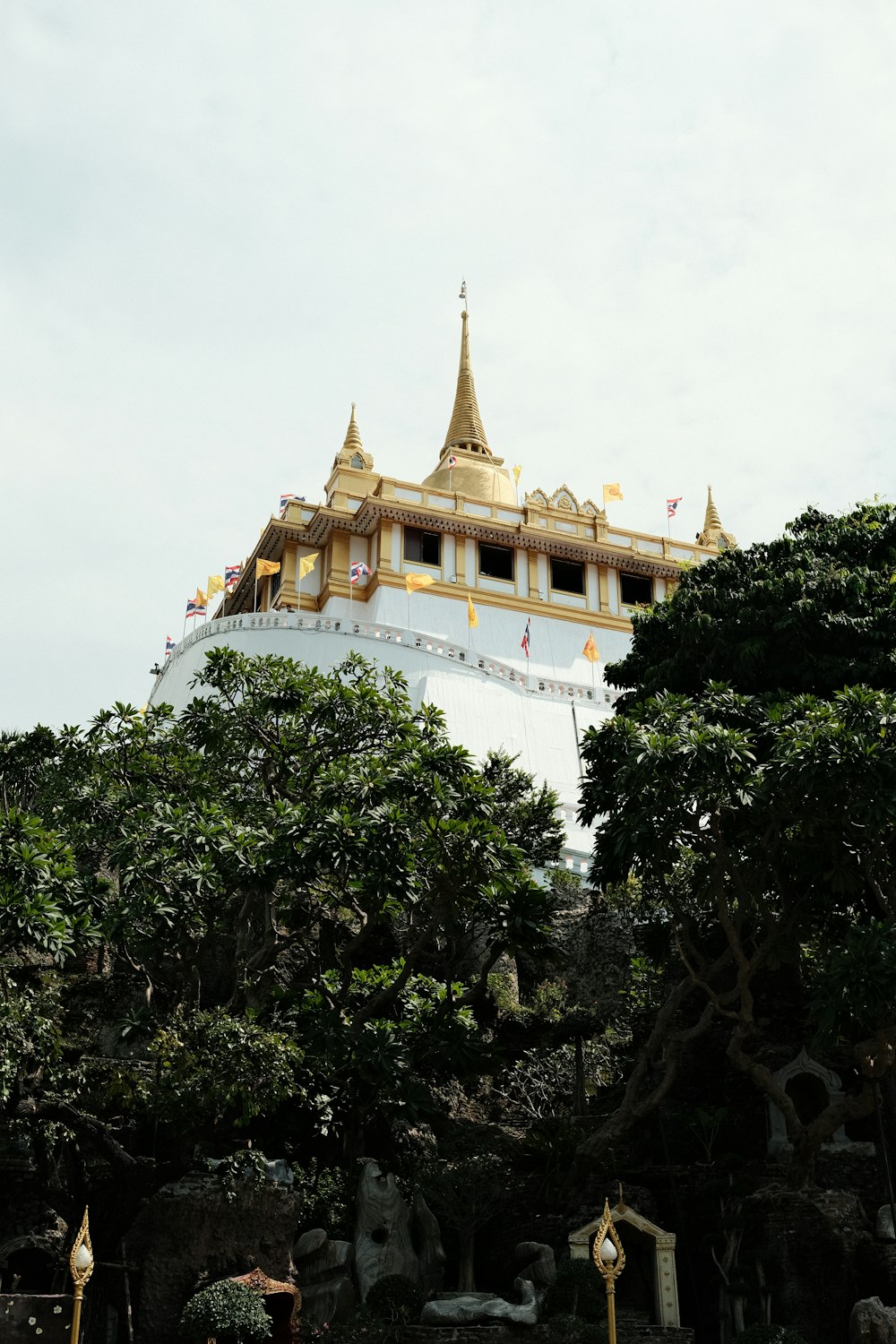 Un gran edificio blanco y dorado rodeado de árboles