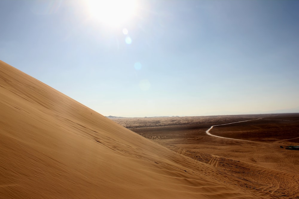 a car driving down a sandy hill in the desert