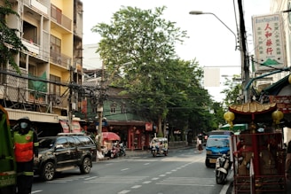 a city street filled with lots of traffic next to tall buildings