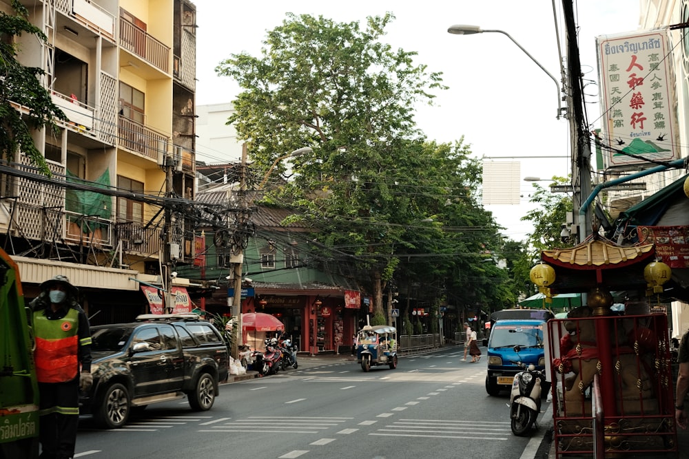 a city street filled with lots of traffic next to tall buildings