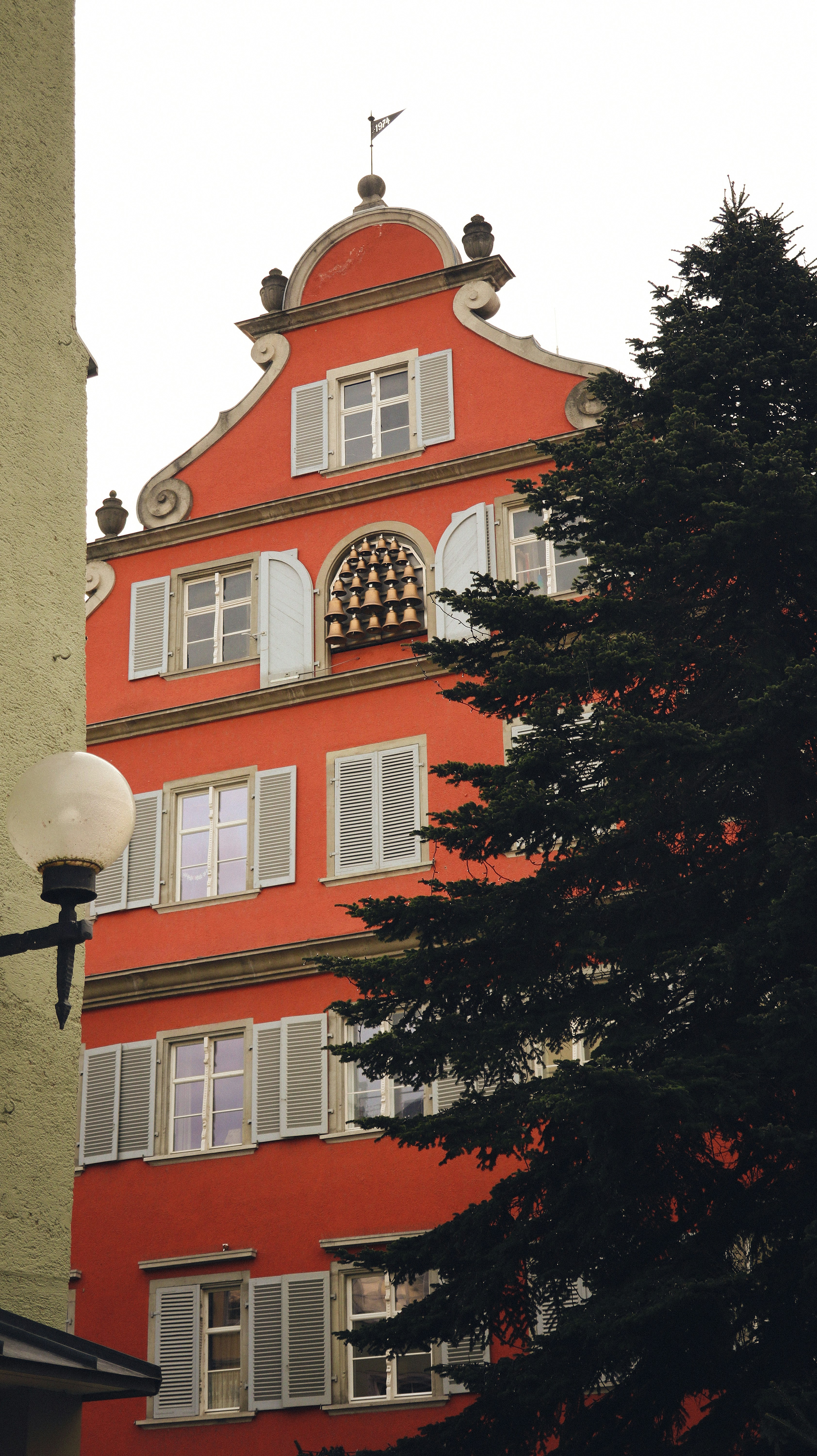 a tall red building with a clock on it's face