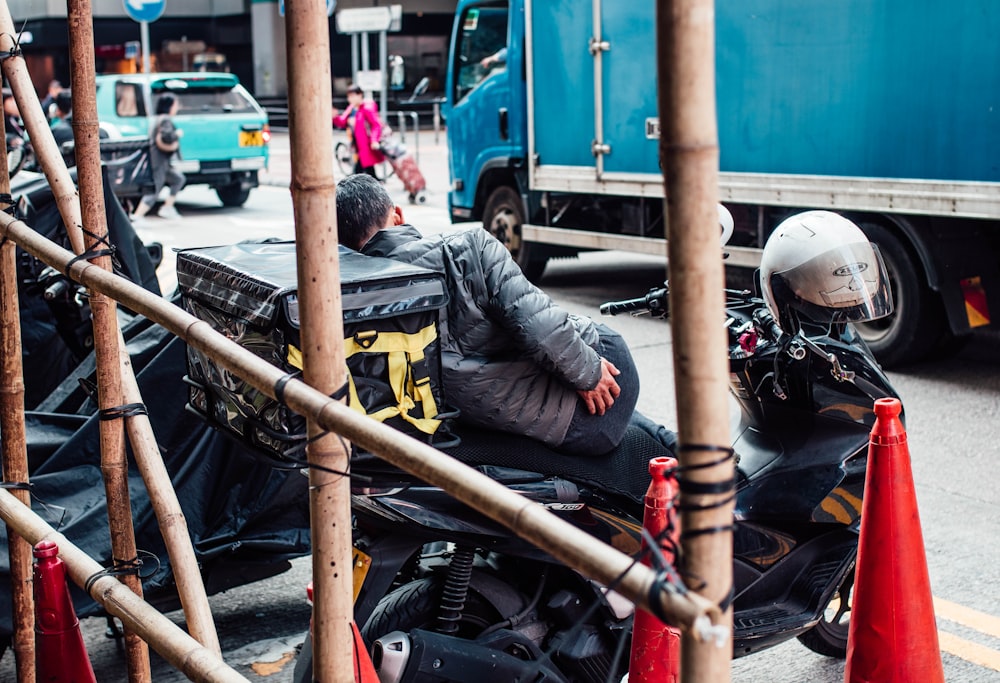 a man riding a motorcycle down a street next to traffic cones