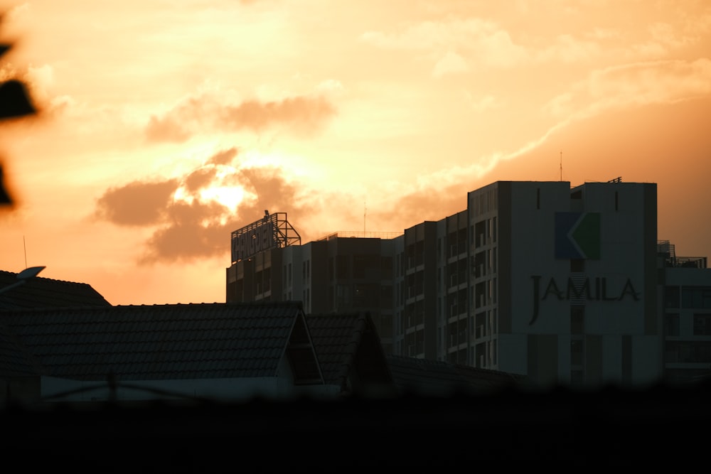 the sun is setting over a city with tall buildings