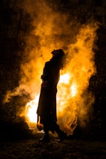 a person standing in front of a fire