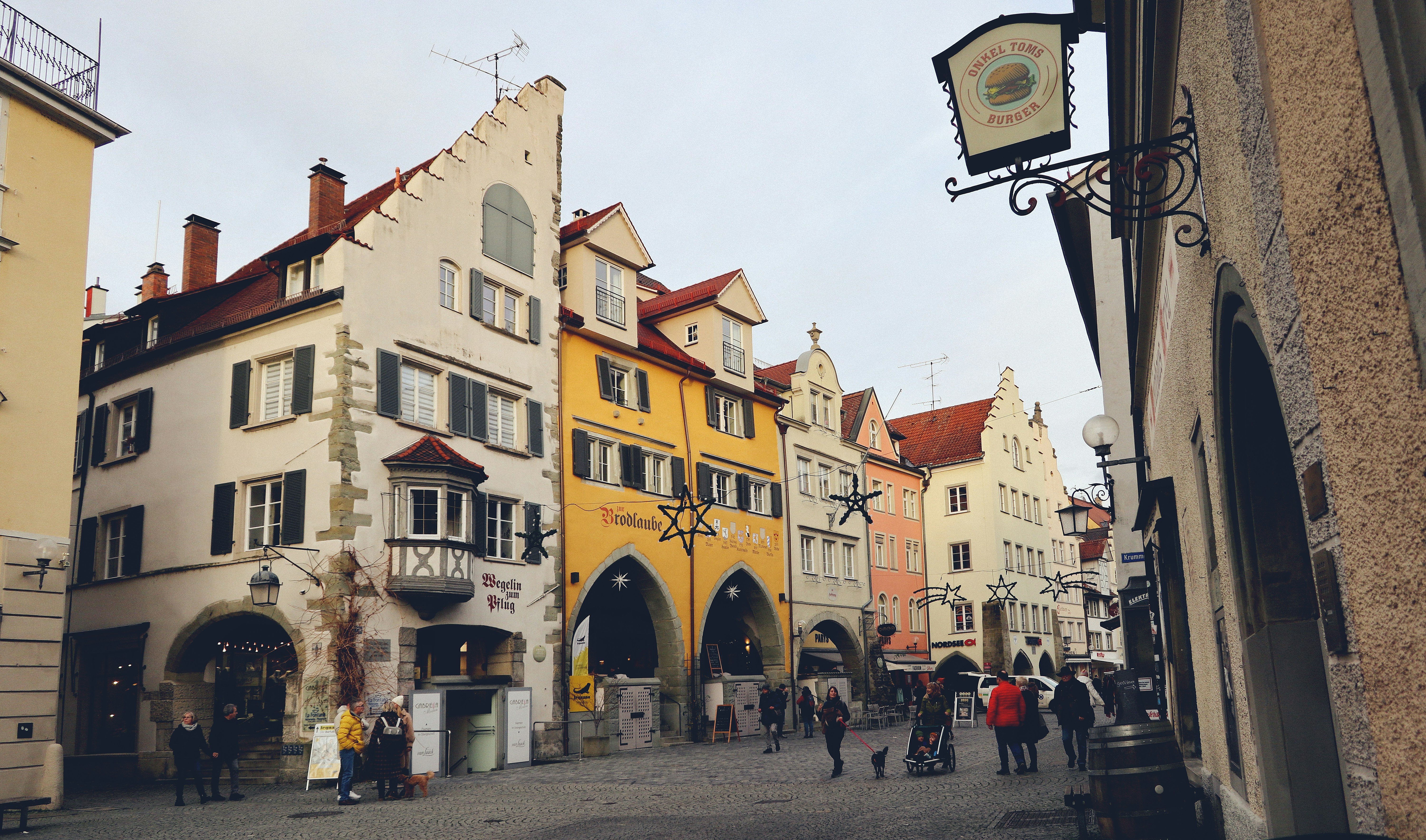 a group of people walking down a street next to tall buildings