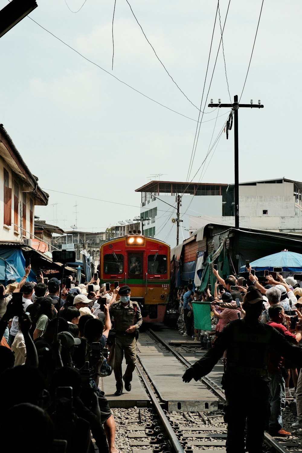 a crowd of people standing on top of a train track