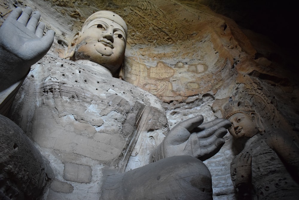 a close up of a statue of buddhas in a cave
