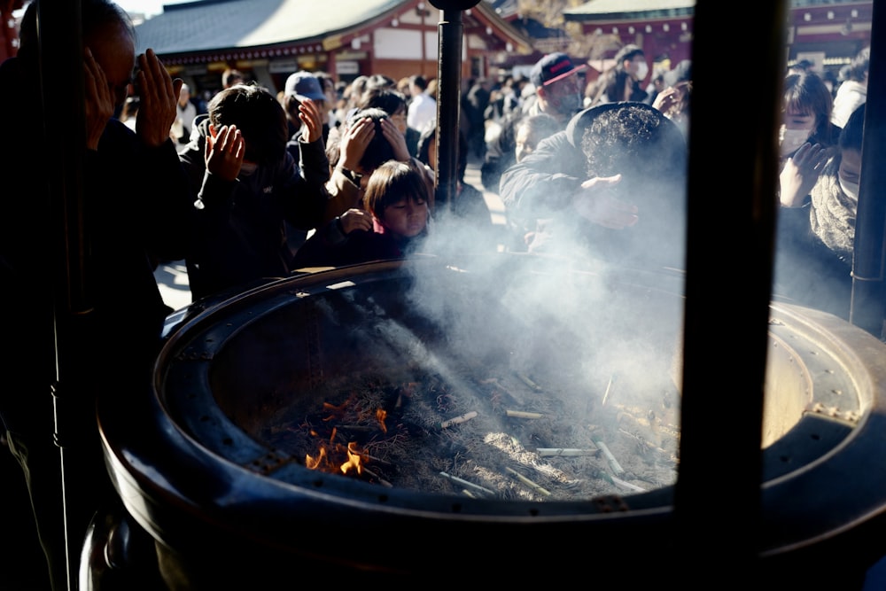 a group of people standing around a fire pit